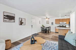 Living area featuring ceiling fan, wood finished floors, and baseboards