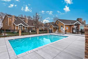 Community pool featuring a patio, fence, and a residential view