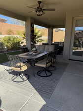 View of patio / terrace featuring outdoor dining area, fence, and a ceiling fan