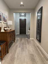 Foyer featuring baseboards, visible vents, and light wood-style floors