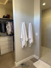 Bathroom with a walk in shower, wood finished floors, visible vents, baseboards, and a spacious closet