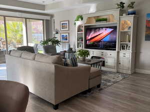 Living area featuring visible vents, ceiling fan, baseboards, and wood finished floors