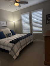 Bedroom featuring carpet floors, a ceiling fan, and baseboards