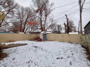 Snowy yard with a gate and a fenced backyard