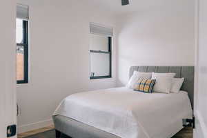 Bedroom featuring ceiling fan, baseboards, and wood finished floors