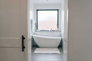 Full bathroom with a freestanding bath and tile patterned floors