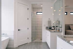 Full bath with a freestanding tub, a shower stall, visible vents, and two vanities