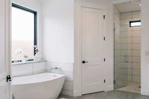 Bathroom featuring a stall shower and a freestanding bath