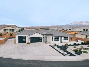 View of front of house with an attached garage, a mountain view, a tile roof, a residential view, and stucco siding