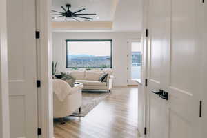 Living room with light wood-type flooring, a raised ceiling, and a mountain view