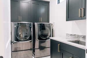 Laundry area featuring cabinet space, a sink, and washing machine and clothes dryer