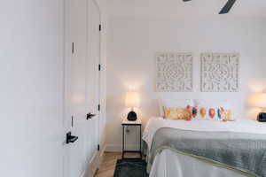 Bedroom with baseboards, a closet, a ceiling fan, and light wood-style floors