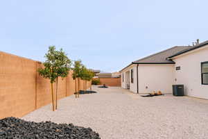 View of yard featuring central AC, a patio, and a fenced backyard