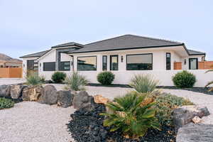 View of front of property with fence, a tiled roof, and stucco siding