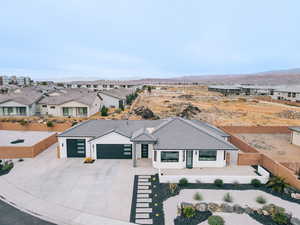 View of front facade featuring a mountain view, a garage, a residential view, driveway, and a tiled roof