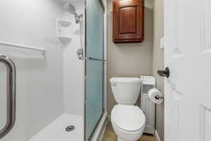 Primary Bedroom's Bathroom featuring a stall shower and toilet