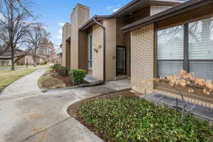 Doorway to property featuring brick siding