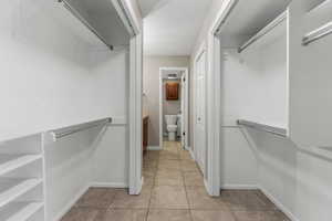 Walk in closet with light tile patterned floors