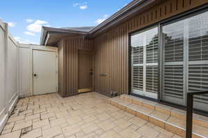 View of private patio with entrance to the 2 car garage