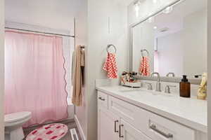 Bathroom with shower / bath combination with curtain, visible vents, toilet, vanity, and wood finished floors