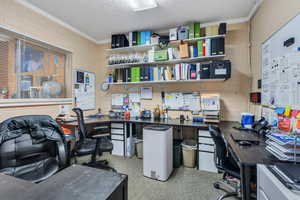 Home office featuring a workshop area, a textured ceiling, and ornamental molding