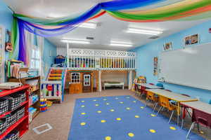 Rec room with carpet flooring and a textured ceiling