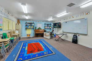 Game room featuring carpet floors and a textured ceiling