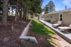 View of yard with fence and a deck