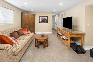 Living area with , baseboards, recessed lighting, and light colored carpet