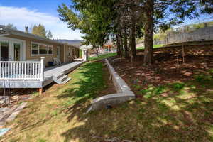 View of yard featuring french doors, a deck with mountain view, and fence