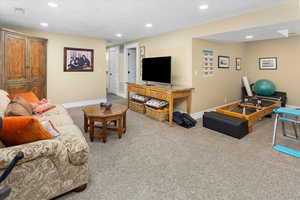 Carpeted living area with baseboards, and recessed lighting