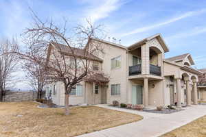 View of front facade featuring a balcony and a front lawn