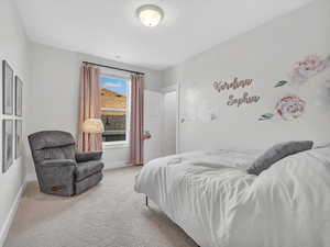 Bedroom featuring light carpet