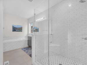 Bathroom with a garden tub, tile flooring, double vanity, and a walk-in shower