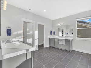 Bathroom featuring tile flooring, two vanities