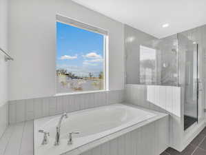 Bathroom featuring a garden tub, tile floors, and a walk in shower