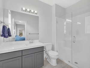 Ensuite bathroom featuring tile flooring, vanity, and a walk in shower