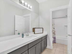 Full bathroom featuring shower/bathtub combination with vanity, and tile floors