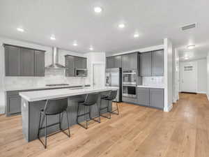 Kitchen with stainless steel appliances,  white countertops, and a kitchen bar