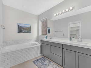 Full bath with a garden tub, double vanity, and tile floors