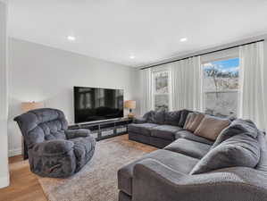 Living room with wood style LVP finished floors, and recessed lighting