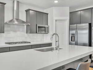 Kitchen featuring a sink, a breakfast bar area, white countertops, and appliances with stainless steel finishes