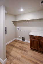 Laundry room featuring hookup for a washing machine, light wood-type flooring, electric dryer hookup, and gas dryer hookup