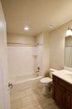 Full bathroom with toilet, a textured ceiling, vanity, and shower / washtub combination