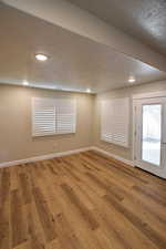 Empty room with hardwood / wood-style flooring and a textured ceiling