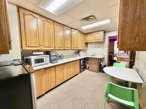 Breakroom with cooler, refrigerator, and light carpet