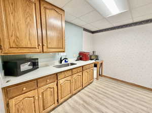 Breakrom featuring a sink, and light hardwood / wood-style flooring