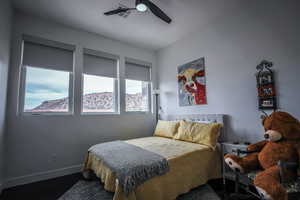 Bedroom featuring dark wood-style floors, a ceiling fan, and baseboards