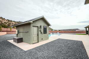 View of outbuilding featuring a fenced backyard, a fenced in pool, and an outbuilding