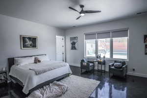 Bedroom with a ceiling fan, visible vents, baseboards, and dark wood-style flooring